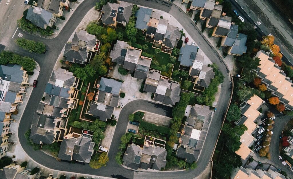 Aerial view of a modern neighborhood with roads and buildings in a lush urban setting.